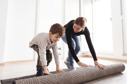 osvc Pojištěná maminka samoživitelka rozbaluje s desetiletým synem koberec