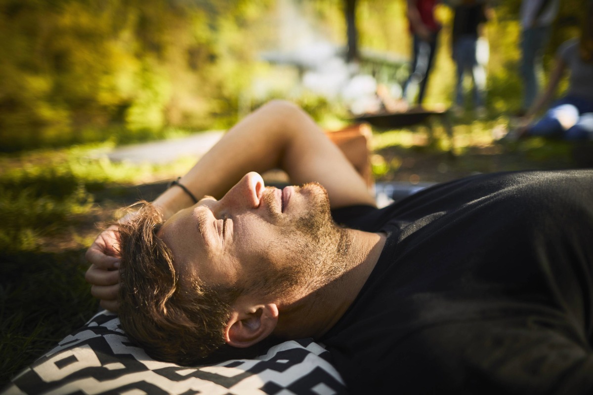 Muž odpočívající na dece jako součást cesty k většímu klidu
